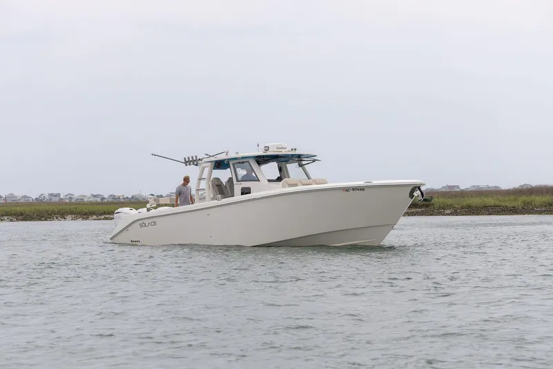  Yacht Photos Pics 2022 Solace 41 CS boat cruising on calm waters near a grassy shoreline.