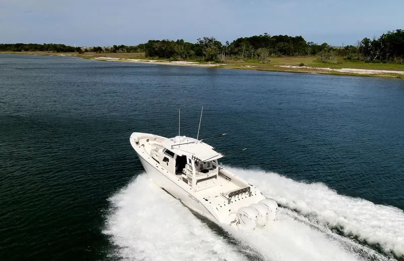  Yacht Photos Pics 2022 Solace 41 CS boat cruising on a scenic lake with lush shoreline.