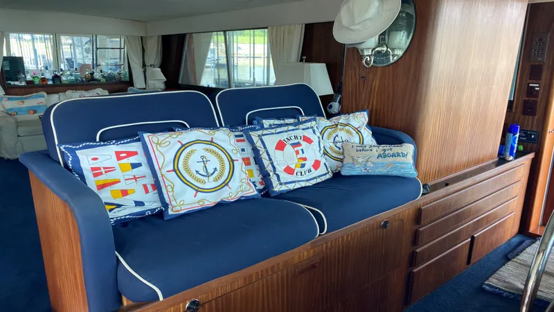  Yacht Photos Pics Interior of 1987 Hatteras 58 Motor Yacht with nautical-themed cushions and wooden cabinetry.
