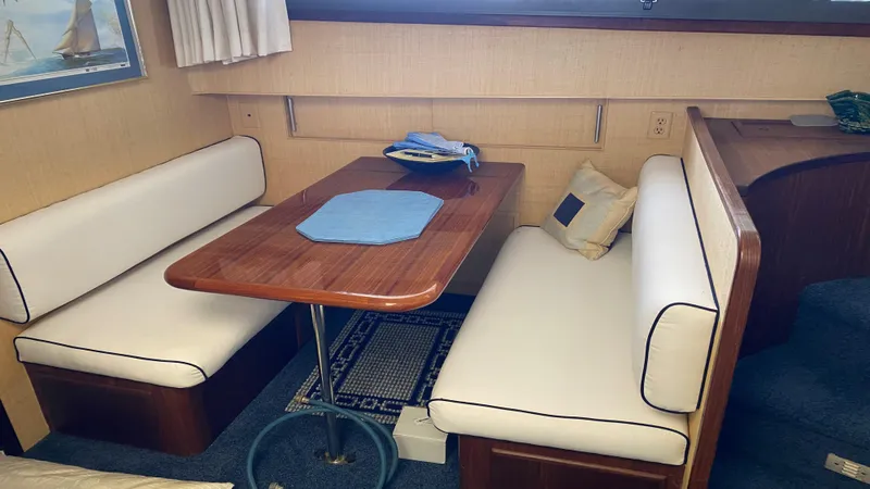  Yacht Photos Pics Interior of 1987 Hatteras 58 Motor Yacht with cozy dining area and wooden table.