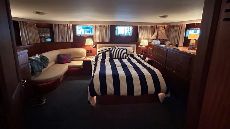  Yacht Photos Pics Luxurious cabin interior of 1987 Hatteras 58 Motor Yacht with striped bedding and cozy seating.