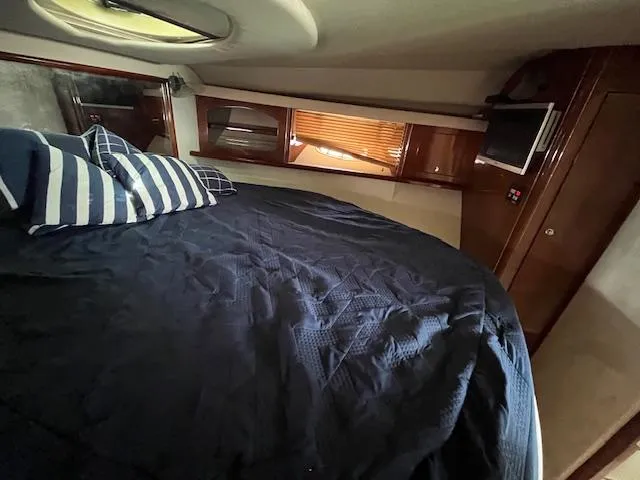 Alacrity Yacht Photos Pics Luxurious cabin interior of 2008 Doral Mediterra yacht with cozy bedding and elegant wood finishes.