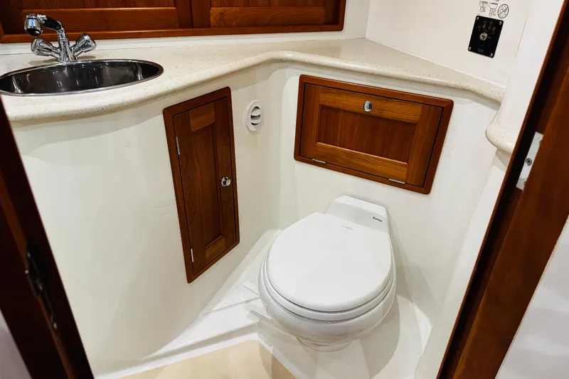 By The Way Yacht Photos Pics 2015 MJM 36z Express yacht bathroom with sink, toilet, and wooden cabinetry.