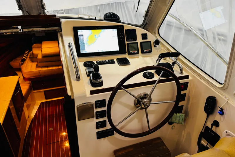 By The Way Yacht Photos Pics 2015 MJM 36z Express yacht helm with navigation controls and wooden steering wheel.