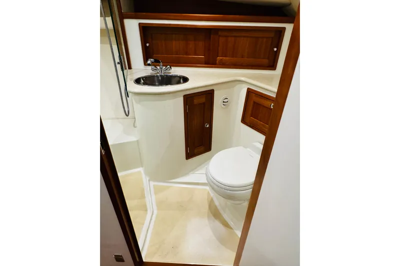 By The Way Yacht Photos Pics 2015 MJM 36z Express yacht bathroom with sink, toilet, and wooden cabinetry.