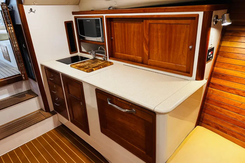 By The Way Yacht Photos Pics 2015 MJM 36z Express yacht interior with wooden cabinetry and modern kitchenette.