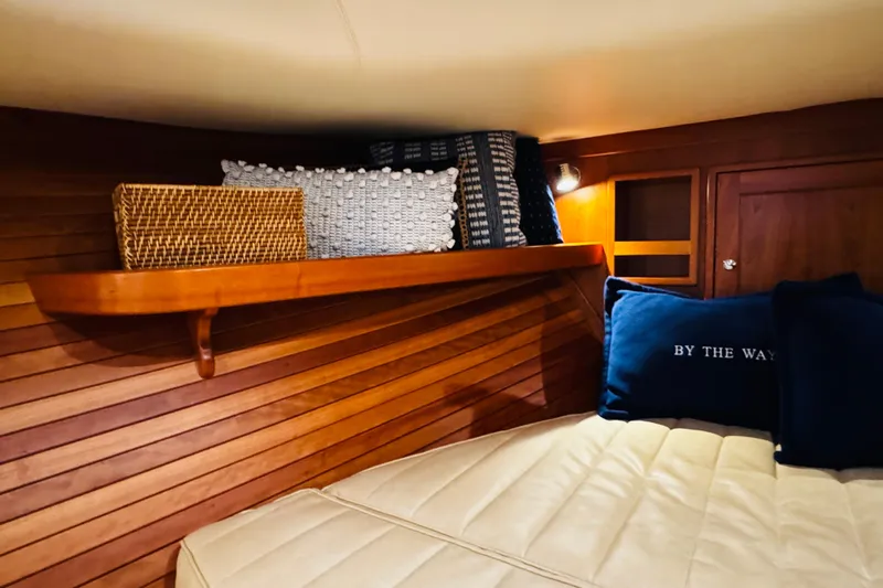 By The Way Yacht Photos Pics Cozy cabin interior of 2015 MJM 36z Express with wooden paneling and decorative pillows.