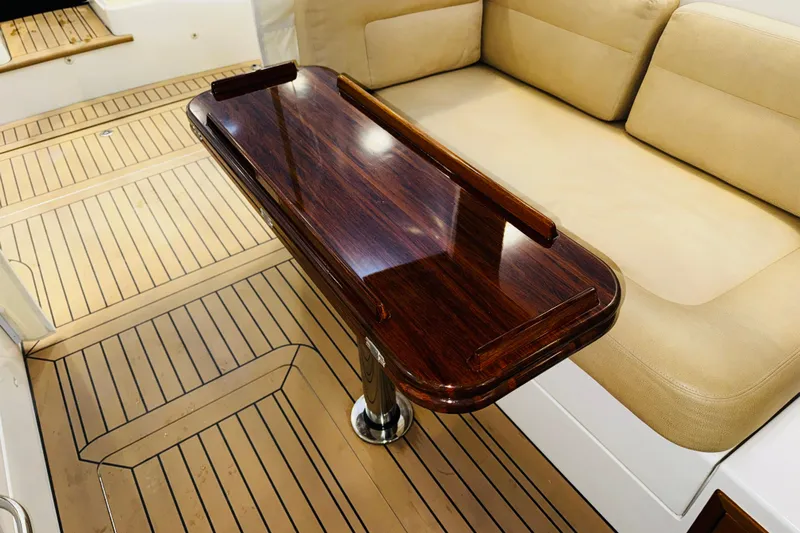 By The Way Yacht Photos Pics Luxurious interior of 2015 MJM 36z Express with wooden table and beige seating.