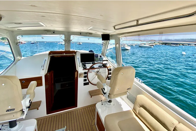 By The Way Yacht Photos Pics Interior view of 2015 MJM 36z Express yacht with helm and seating, overlooking ocean.