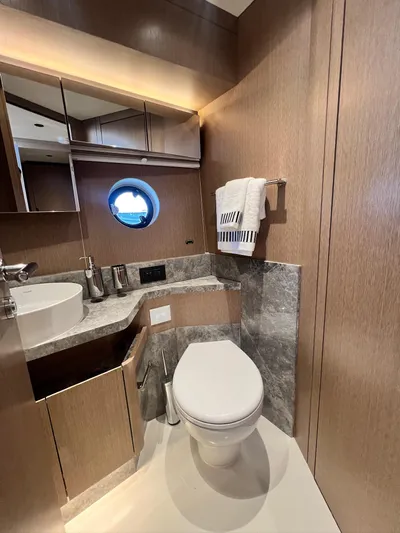  Yacht Photos Pics Luxurious bathroom in 2024 Sirena 48 Flybridge yacht with modern fixtures and porthole window.