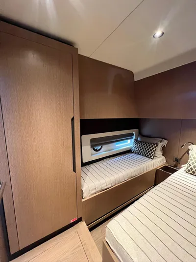  Yacht Photos Pics 2024 Sirena 48 Flybridge cabin with modern wood finish and cozy bedding.