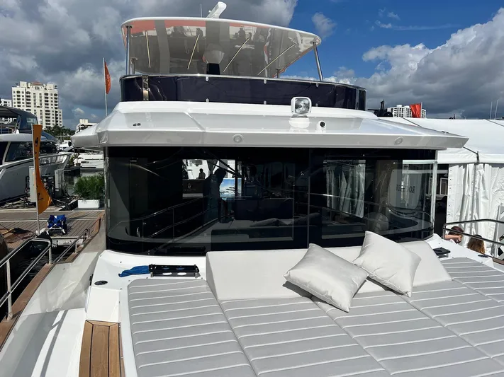  Yacht Photos Pics 2024 Sirena 48 Flybridge yacht with sun deck and cushions, docked under cloudy sky.