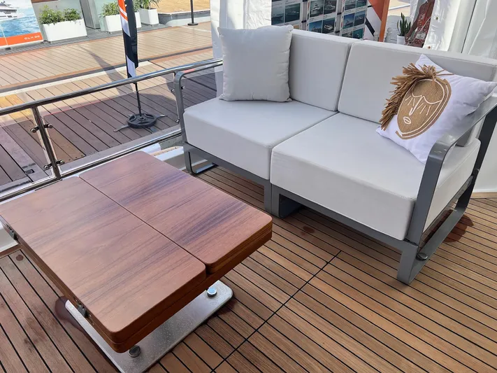  Yacht Photos Pics 2024 Sirena 48 Flybridge yacht deck with white sofa and wooden table.