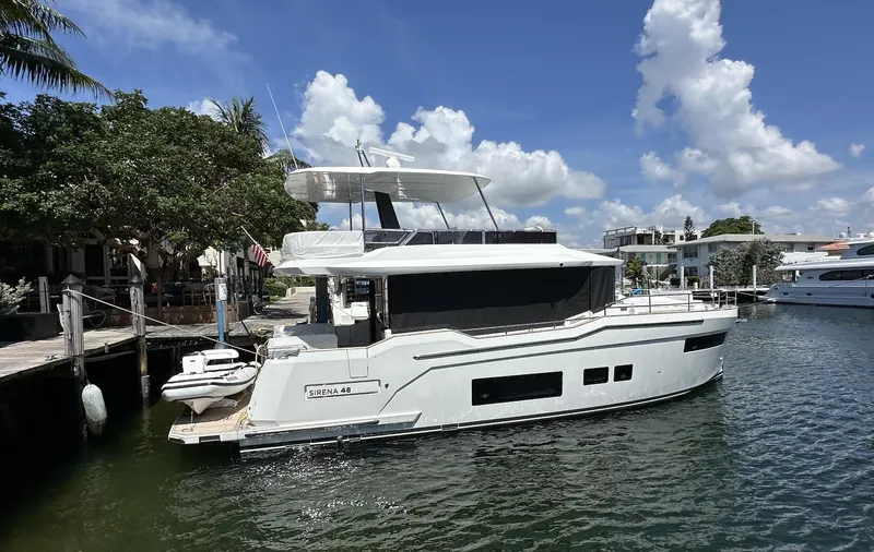  Yacht Photos Pics 2024 Sirena 48 Flybridge yacht docked in a sunny marina setting.
