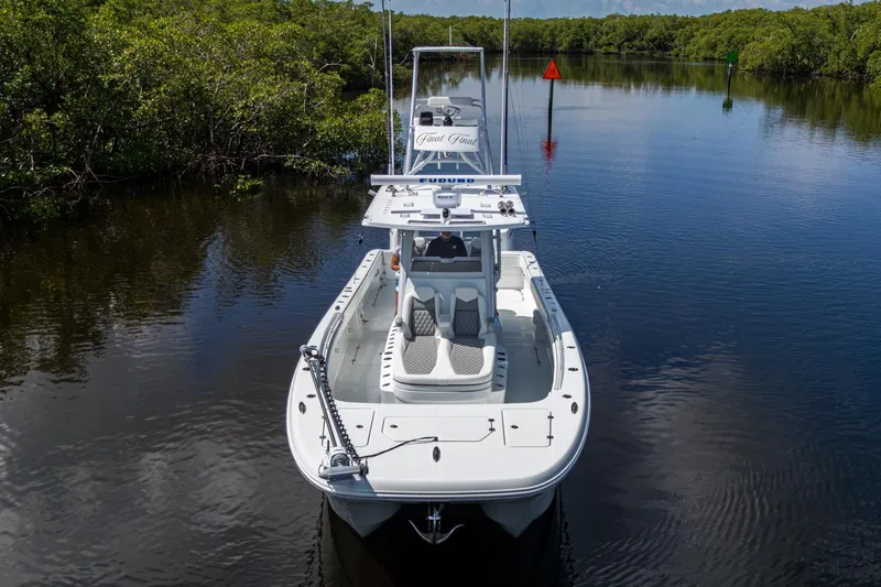 Final/final Yacht Photos Pics 2025 Invincible 33 Catamaran cruising on a calm river, surrounded by lush greenery.