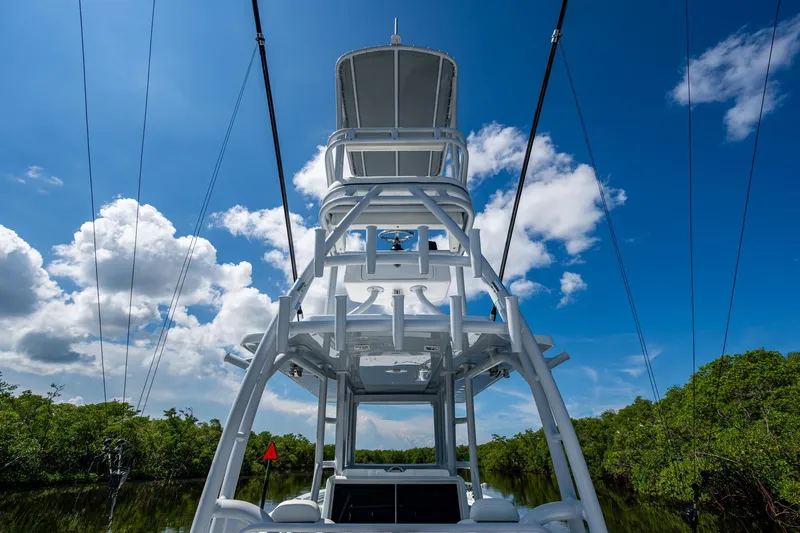 Final/final Yacht Photos Pics 2025 Invincible 33 Catamaran tower against blue sky and lush greenery.