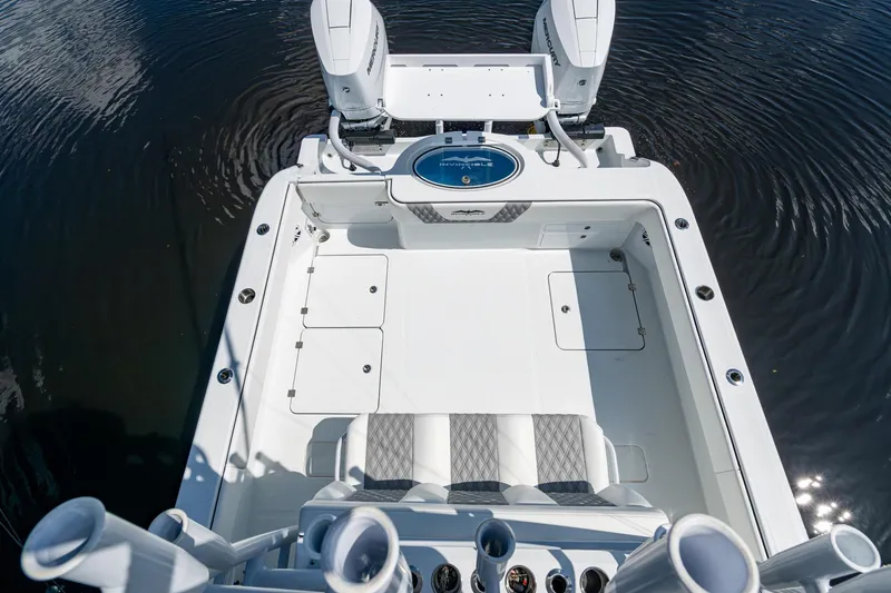 Final/final Yacht Photos Pics 2025 Invincible 33 Catamaran boat deck with dual engines and seating, on calm water.