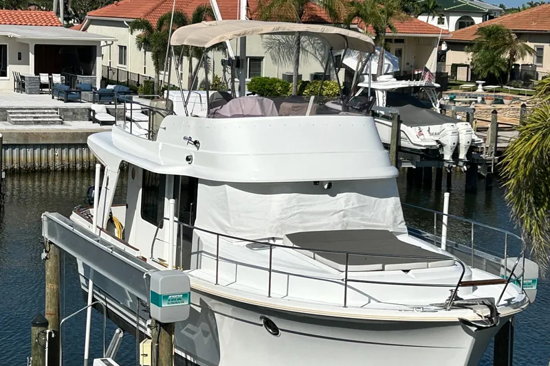 Good Timimg Yacht Photos Pics 2015 Beneteau Swift Trawler 34 docked in a marina, featuring a spacious deck and flybridge.