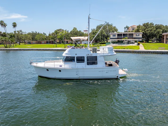 Good Timimg Yacht Photos Pics 2015 Beneteau Swift Trawler 34 cruising on a sunny day near waterfront homes.