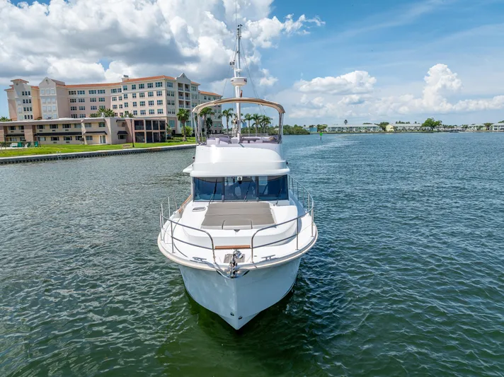 Good Timimg Yacht Photos Pics 2015 Beneteau Swift Trawler 34 on water, with buildings and blue sky in background.