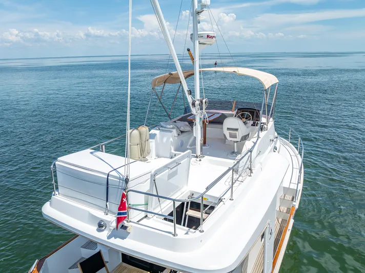 Good Timimg Yacht Photos Pics 2015 Beneteau Swift Trawler 34 on calm sea, featuring spacious deck and helm station.