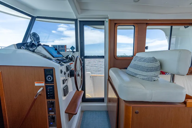 Good Timimg Yacht Photos Pics Interior of 2015 Beneteau Swift Trawler 34, featuring helm and seating area with ocean view.