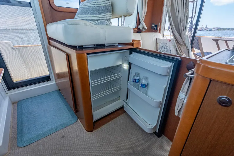 Good Timimg Yacht Photos Pics Interior of 2015 Beneteau Swift Trawler 34 with open mini fridge and seating area.