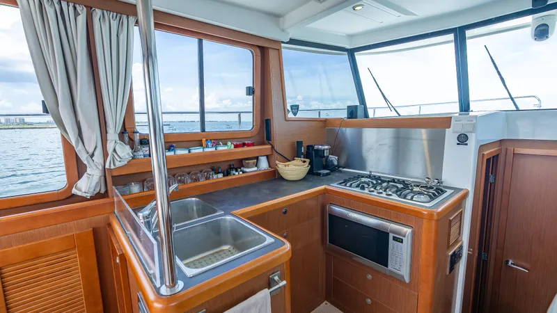 Good Timimg Yacht Photos Pics Interior of 2015 Beneteau Swift Trawler 34 kitchen with stove, sink, and microwave.
