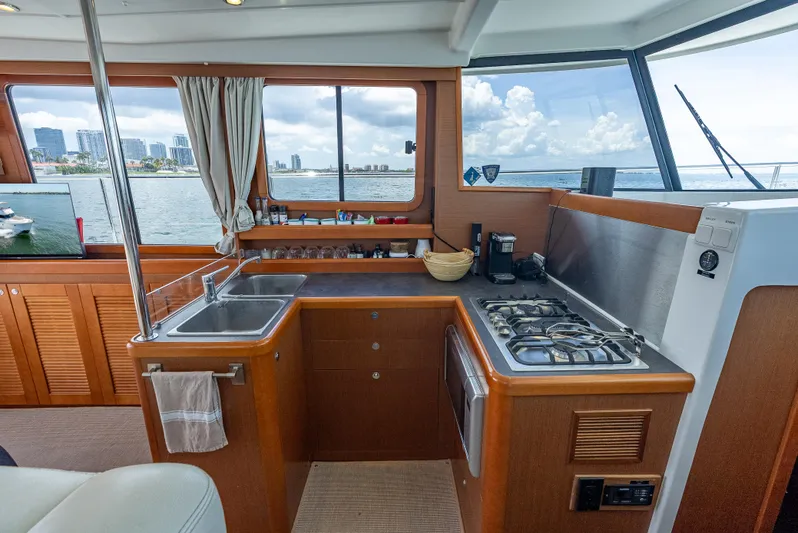 Good Timimg Yacht Photos Pics Interior of 2015 Beneteau Swift Trawler 34, featuring a compact kitchen with ocean view.