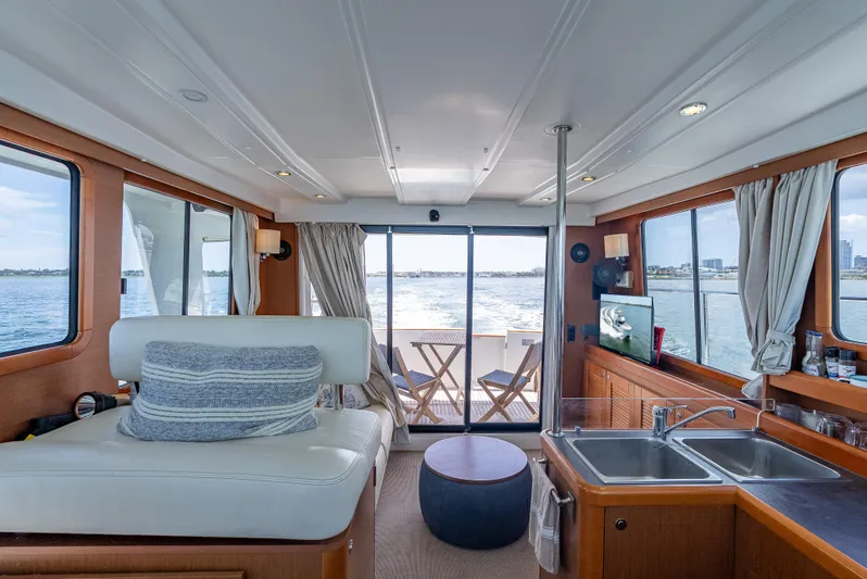 Good Timimg Yacht Photos Pics Interior of 2015 Beneteau Swift Trawler 34, featuring cozy seating, kitchen, and ocean view.