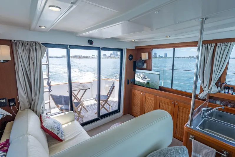 Good Timimg Yacht Photos Pics Interior of 2015 Beneteau Swift Trawler 34, featuring cozy seating, TV, and ocean view.