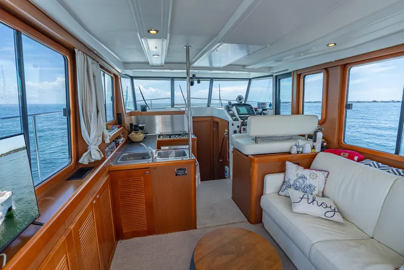 Good Timimg Yacht Photos Pics Interior of 2015 Beneteau Swift Trawler 34 with kitchen, seating, and ocean view.