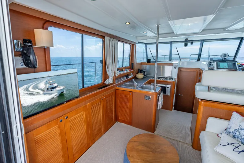 Good Timimg Yacht Photos Pics Interior of 2015 Beneteau Swift Trawler 34, featuring kitchen, seating, and ocean view.