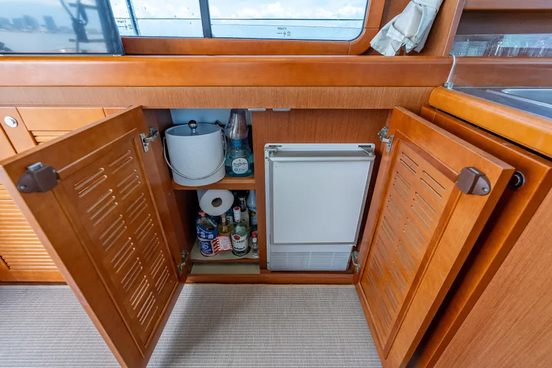 Good Timimg Yacht Photos Pics Interior of 2015 Beneteau Swift Trawler 34 with open cabinet and mini fridge.