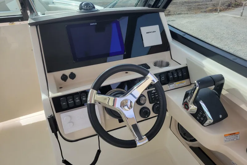  Yacht Photos Pics 2023 Boston Whaler 280 Vantage helm with steering wheel, controls, and navigation display.
