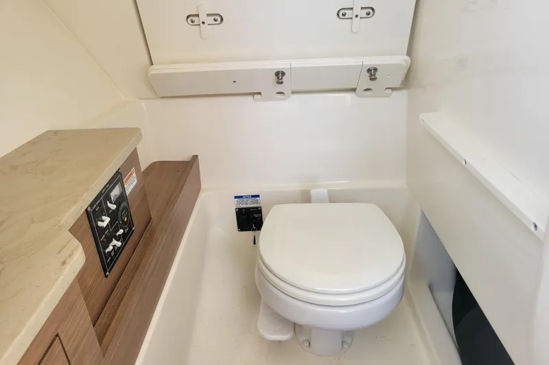  Yacht Photos Pics 2023 Boston Whaler 280 Vantage boat bathroom with toilet and control panel.