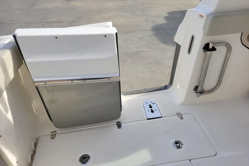  Yacht Photos Pics 2023 Boston Whaler 280 Vantage boat deck with storage compartments and safety handle.