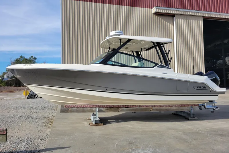  Yacht Photos Pics 2023 Boston Whaler 280 Vantage boat on display outside a large warehouse.