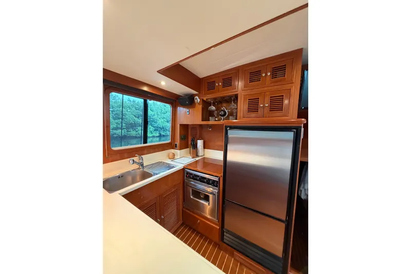 Angels Envy Yacht Photos Pics Luxurious 2006 North Pacific 42 yacht kitchen with stainless steel appliances and wooden cabinetry.