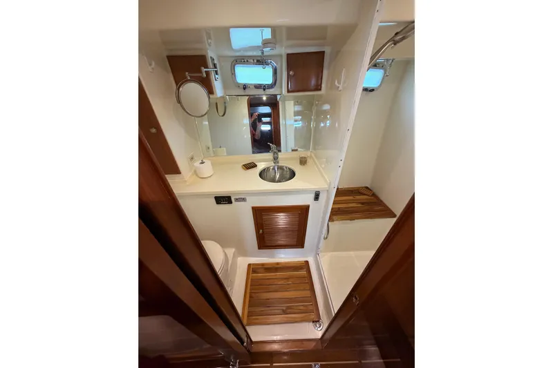 Angels Envy Yacht Photos Pics 2006 North Pacific 42 yacht bathroom with sink, mirror, and wooden accents.