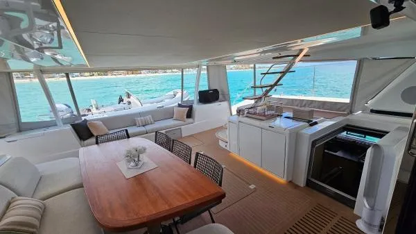 Sunlove Yacht Photos Pics Luxurious interior of 2024 Lagoon SIXTY 7 yacht with dining area and ocean view.