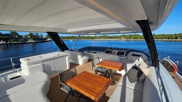 Sunlove Yacht Photos Pics Luxurious 2024 Lagoon SIXTY 7 yacht deck with seating and scenic water view.