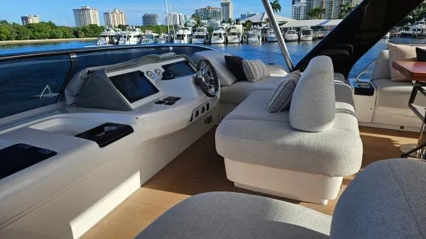 Sunlove Yacht Photos Pics Luxurious 2024 Lagoon SIXTY 7 yacht interior with plush seating and modern dashboard, docked at marina.