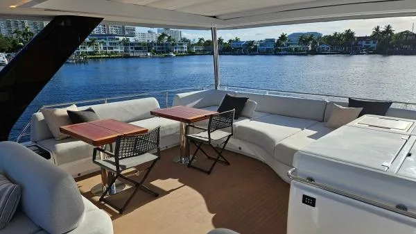 Sunlove Yacht Photos Pics Luxurious 2024 Lagoon SIXTY 7 yacht deck with seating, tables, and waterfront view.
