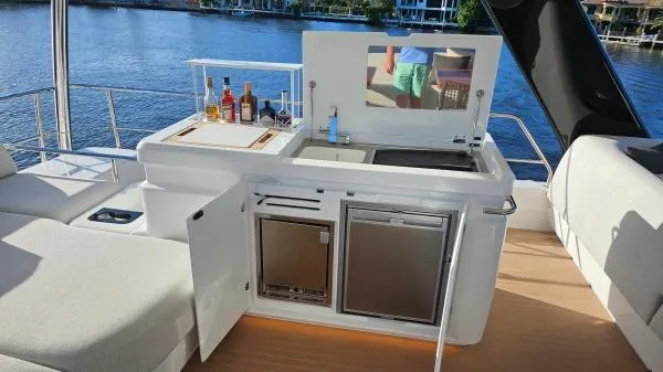 Sunlove Yacht Photos Pics Outdoor kitchenette on 2024 Lagoon SIXTY 7 yacht with drinks and appliances by the water.