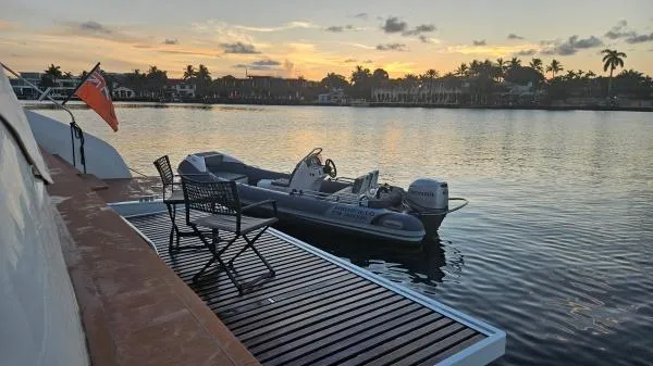 Sunlove Yacht Photos Pics 2024 Lagoon SIXTY 7 yacht with tender at sunset, featuring a serene waterfront view.