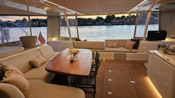 Sunlove Yacht Photos Pics Luxurious 2024 Lagoon SIXTY 7 yacht interior with elegant seating and waterfront view.