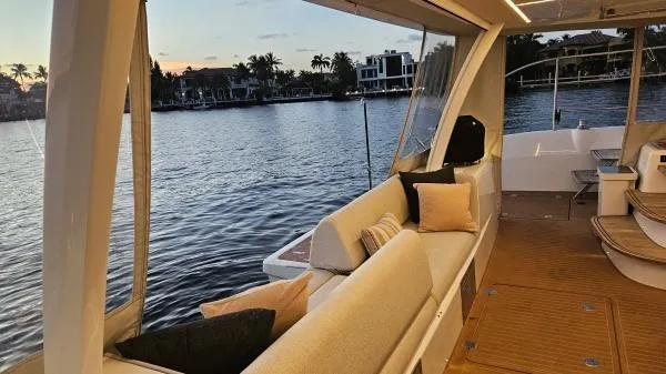 Sunlove Yacht Photos Pics Luxurious 2024 Lagoon SIXTY 7 yacht interior with waterfront view at sunset.
