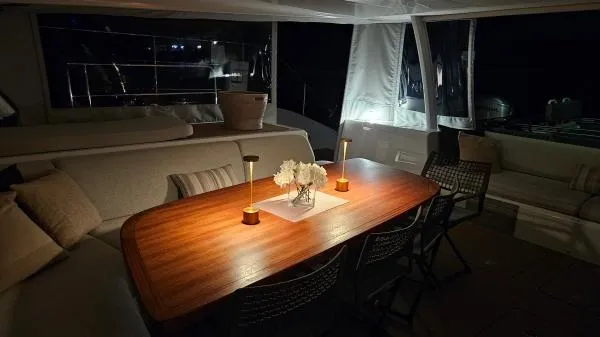 Sunlove Yacht Photos Pics Luxurious 2024 Lagoon SIXTY 7 yacht interior with elegant dining area at night.