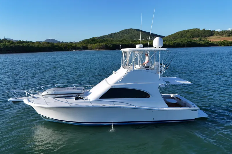  Yacht Photos Pics 2005 Luhrs 38 Convertible yacht cruising on calm waters with scenic background.